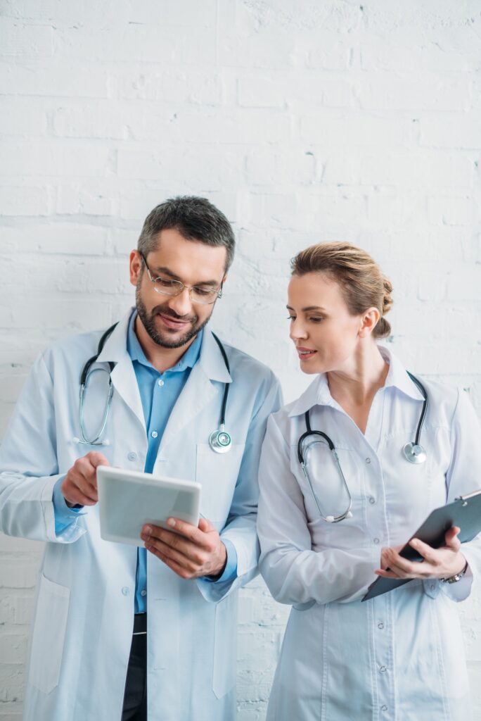 doctors working together with tablet and clipboard