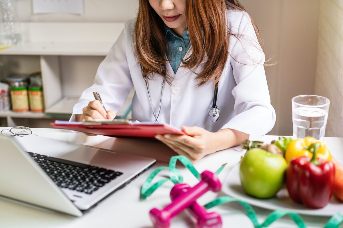 Nutritionist giving consultation to patient with healthy fruit and vegetable